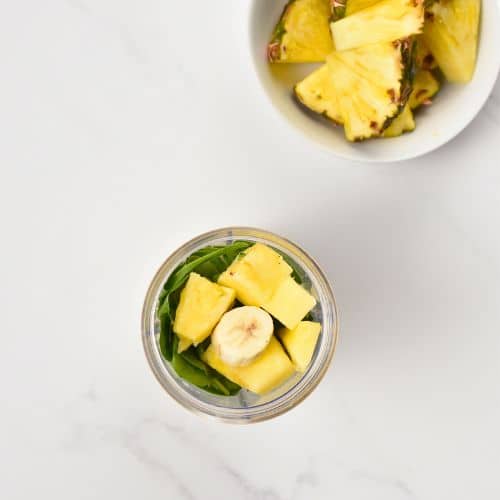 Spinach Pineapple Banana Smoothie ingredients in a blender.