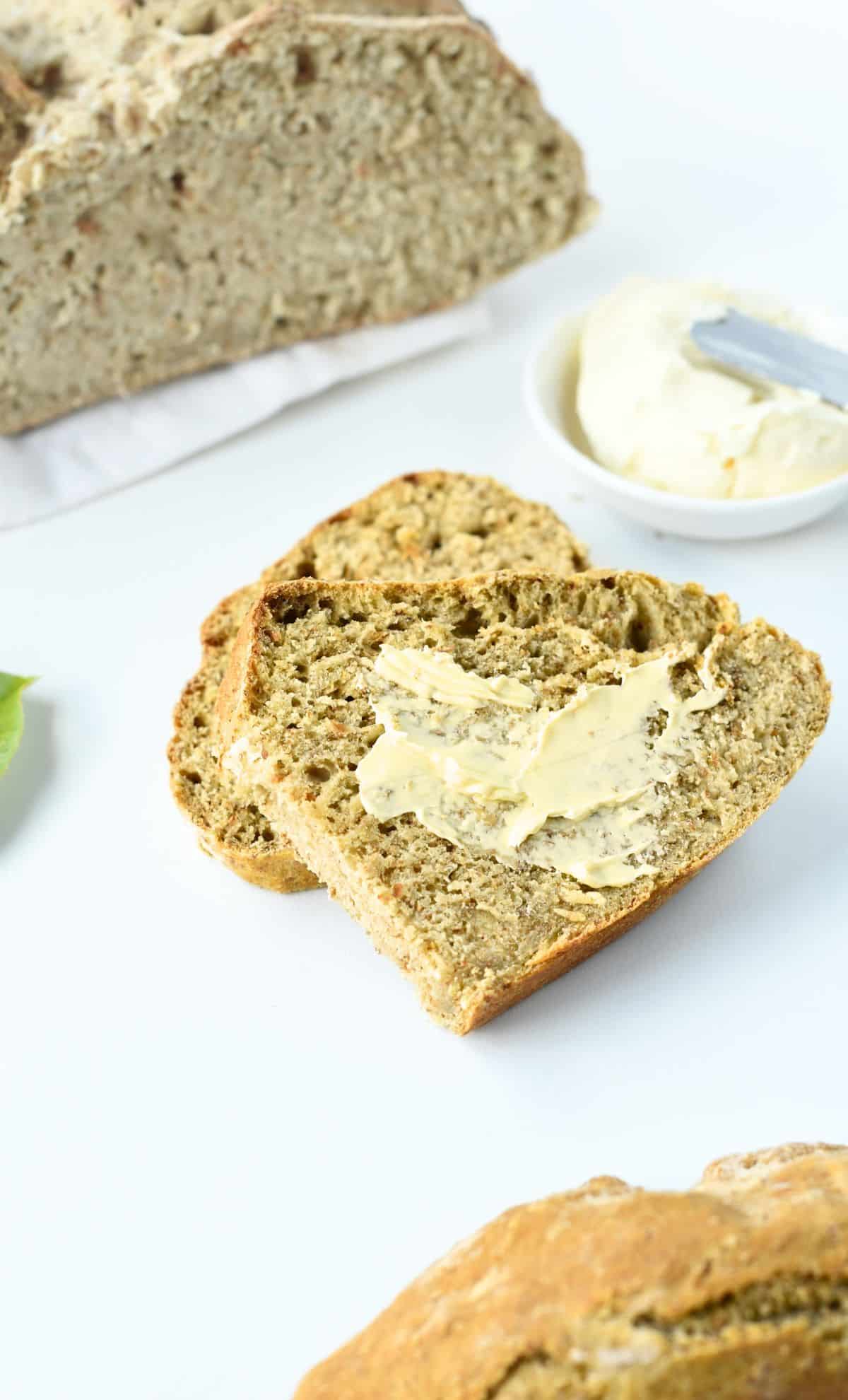 Vegan Irish Soda Bread with vegan butter spread on a slice.
