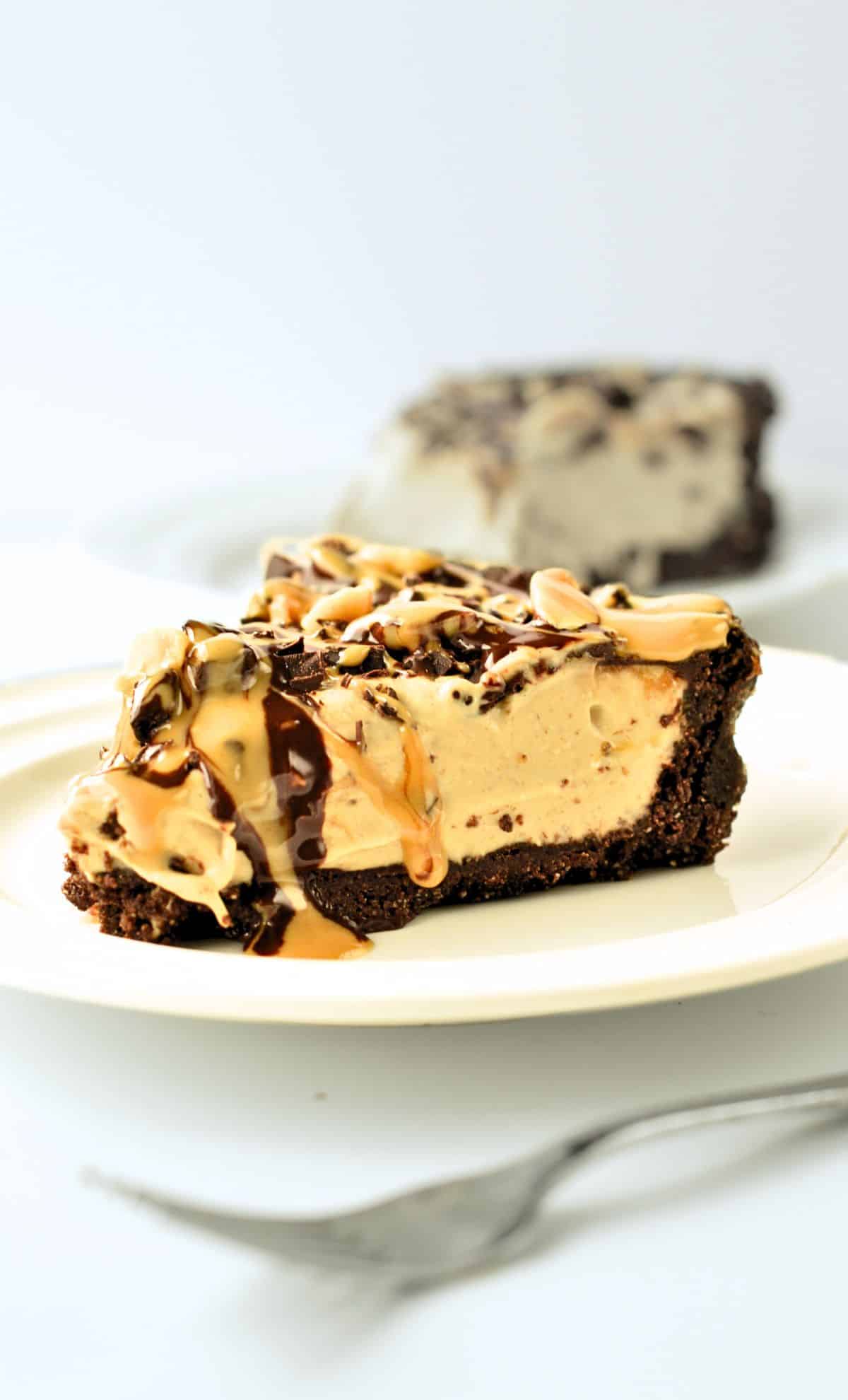 Vegan No-Bake Peanut Butter Pie slice decorated with peanut butter and chocolate chunks.