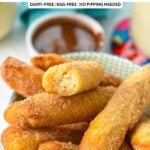 a bowl filled with golden air fryer churros coated with cinnamon sugar and a blue towel in the background