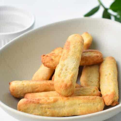 air fryer churros in a mixing bowl before being coated with cinnamon sugar