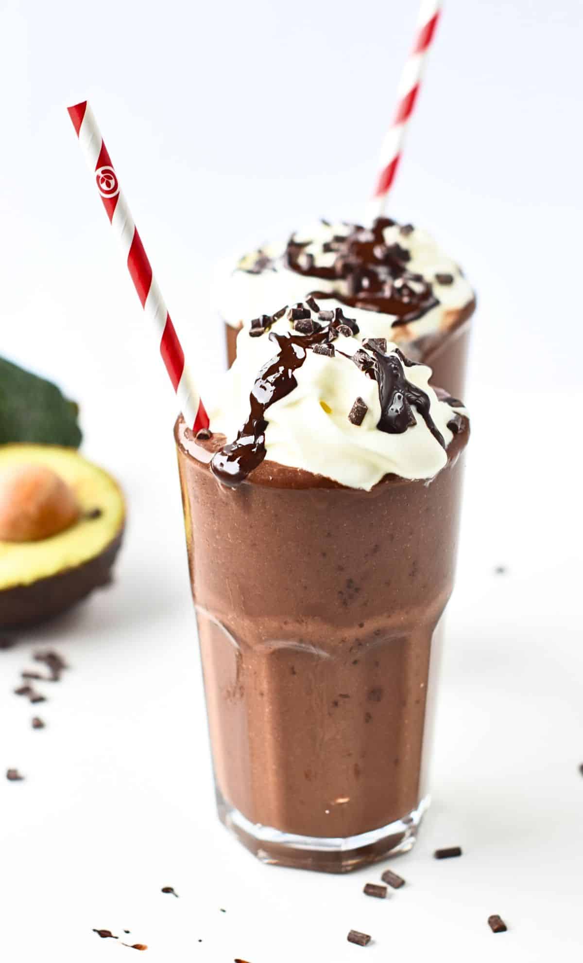 Chocolate Avocado Smoothie decorated with whipped cream, melted chocolate, and chocolate chips.