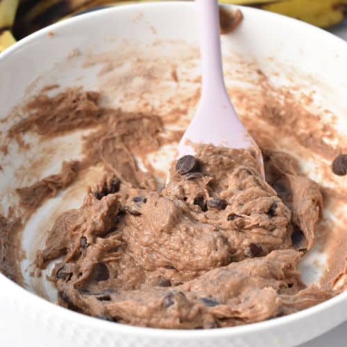 Banana Protein Cookie batter with chocolate chips in a mixing bowl with a silicone spatula.