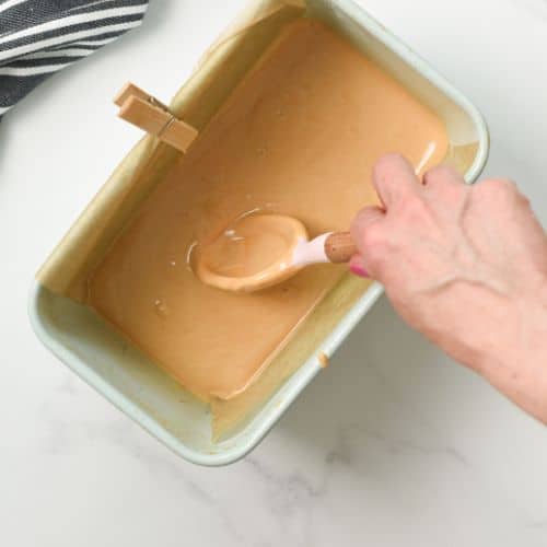 Stirring the 2-ingredient peanut butter batter in a loaf pan.