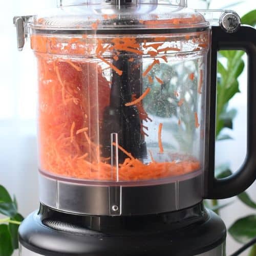 Shredded carrots in a food processor.