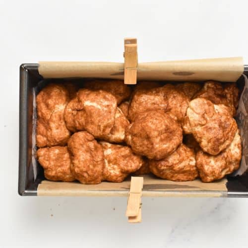 Cinnamon-coated banana monkey bread dough balls in a loaf pan.