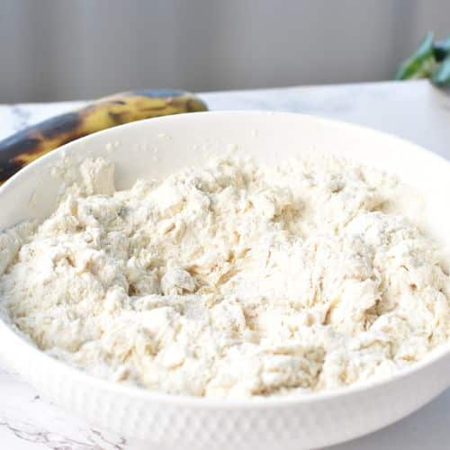 Mixing banana monkey bread dough ingredients in a mixing bowl.