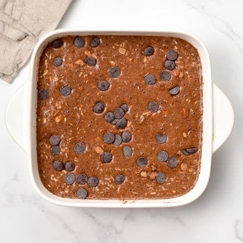 Brownie oatmeal in a large square pan ready to be baked.