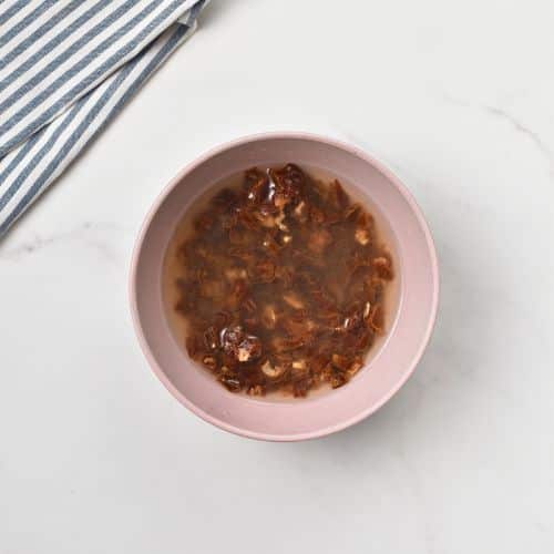 Dates soaking in a small bowl.