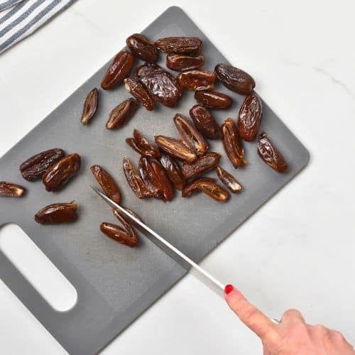 Slicing dates on a chopping board.