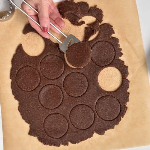 Healthy thin mint cookie batter rolled, cut into cookies, with one lifted on a spatula.