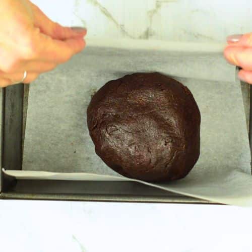 Ball of no-bake brownies dough in a loaf pan.