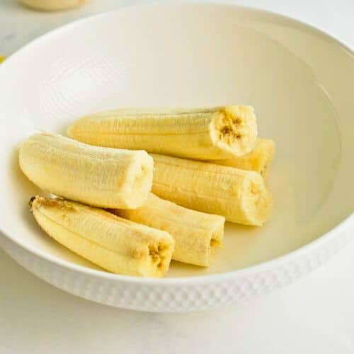 Bananas peeled in a mixing bowl.
