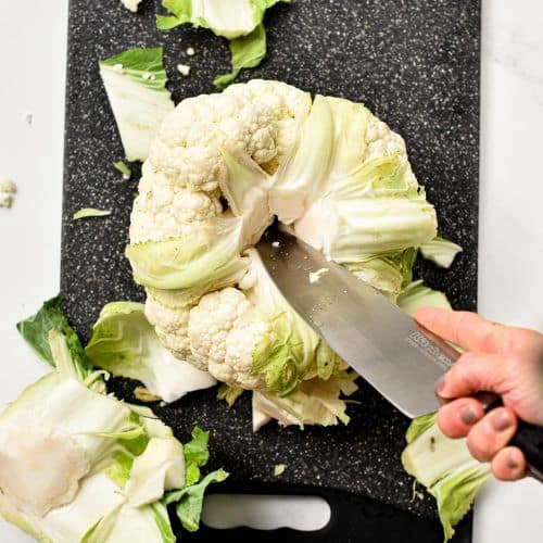 Kitchen knife cutting the feet of cauliflower.