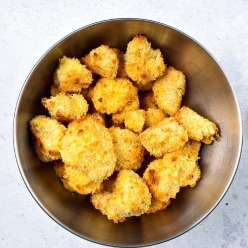 Crumbed cauliflower florets in a large mixing bowl.