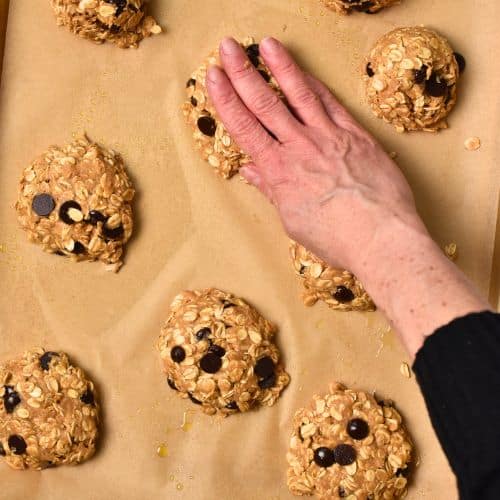 Flattening Protein Oatmeal Cookies with the hand.