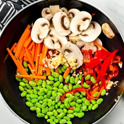 Stir-frying vegetables in a large pan.