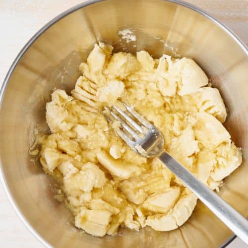 Mashing bananas in a bowl.