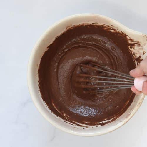 Mixing vegan chocolate cupcake batter in a large mixing bowl.