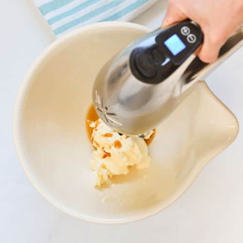 Beating butter and vanilla in a mixing bowl.