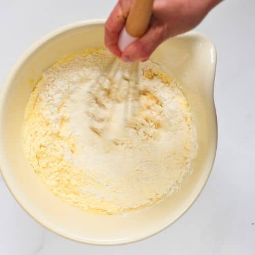 Combining vegan cornbread batter in a mixing bowl.