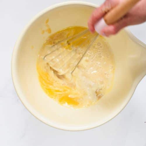 Stirring wet vegan cornbread batter ingredients.
