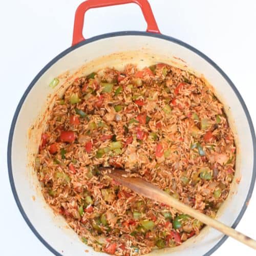 Vegan jambalaya base cooking in a cast-iron pan.