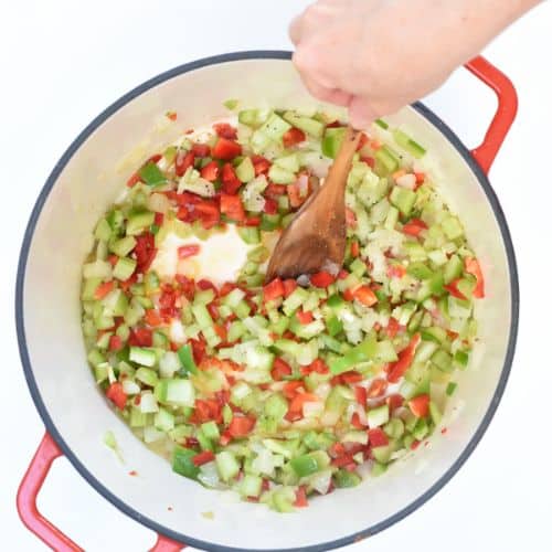 Cooking vegetables in a large cast-iron pan.