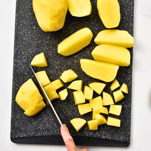 Slicing potatoes on a chopping board.