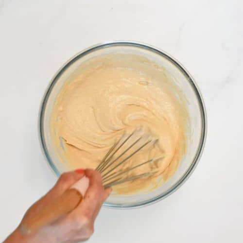 Stirring the vegan protein pancake batter in a mixing bowl.