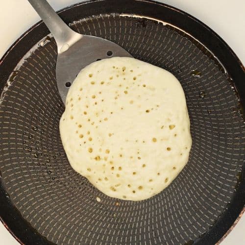 One side of the vegan protein pancakes  cooked on a crepe pan.