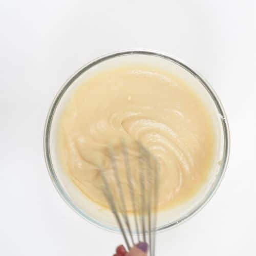 Stirring vegan cupcake batter in a mixing bowl.