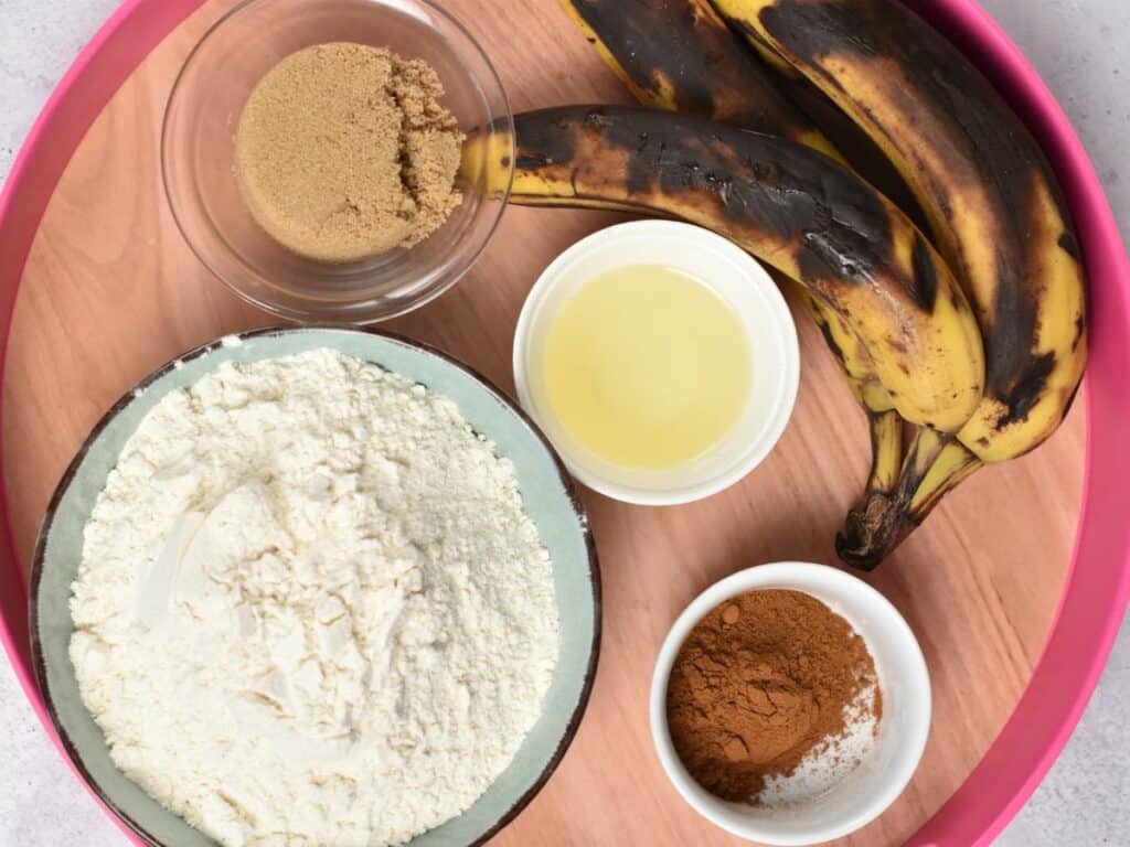 Ingredients for the banana monkey bread in bowls and ramekins on a large serving tray.