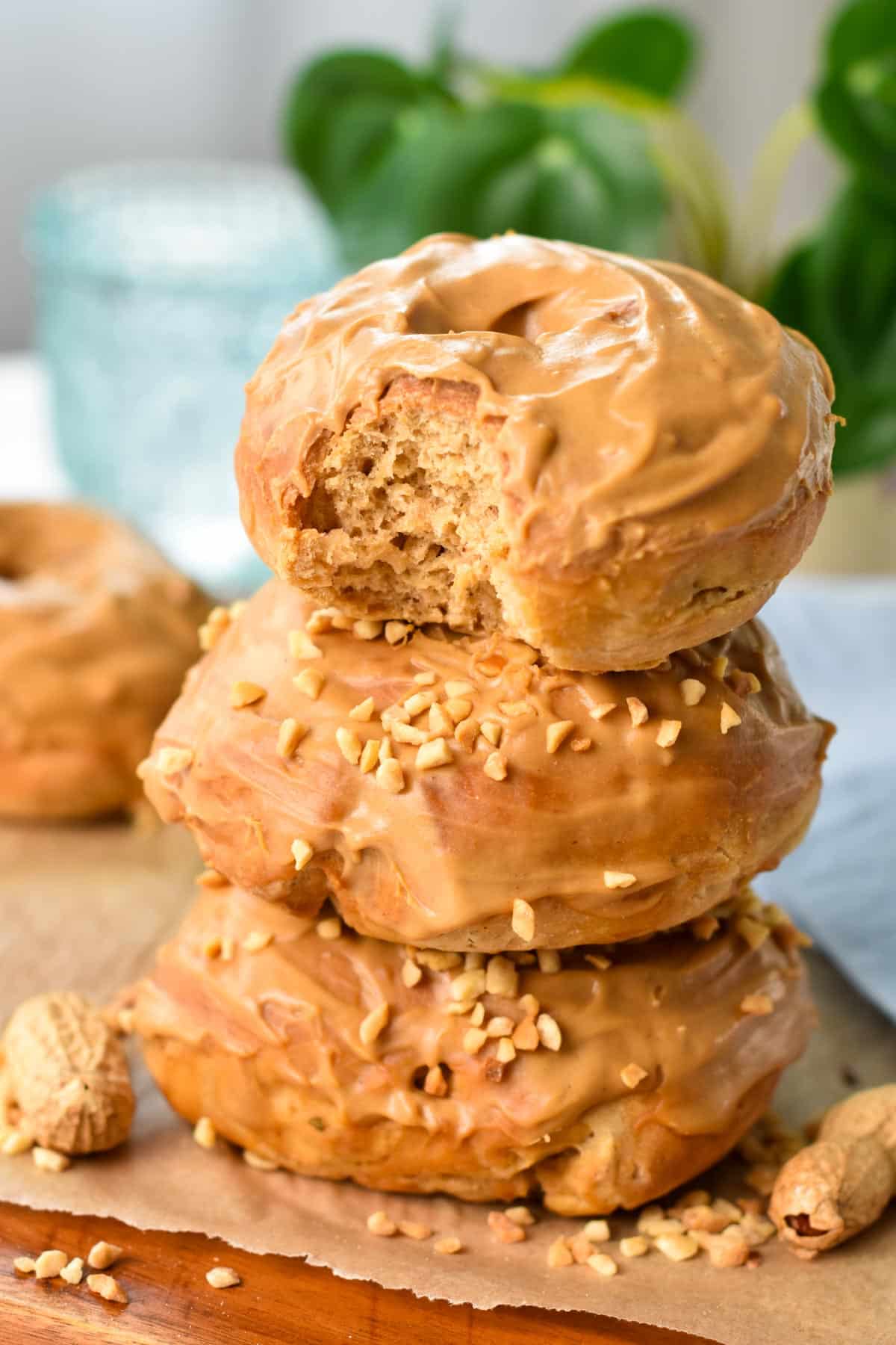 a stack of three peanut butter donuts with the one on top beaten showing its fluffy texture