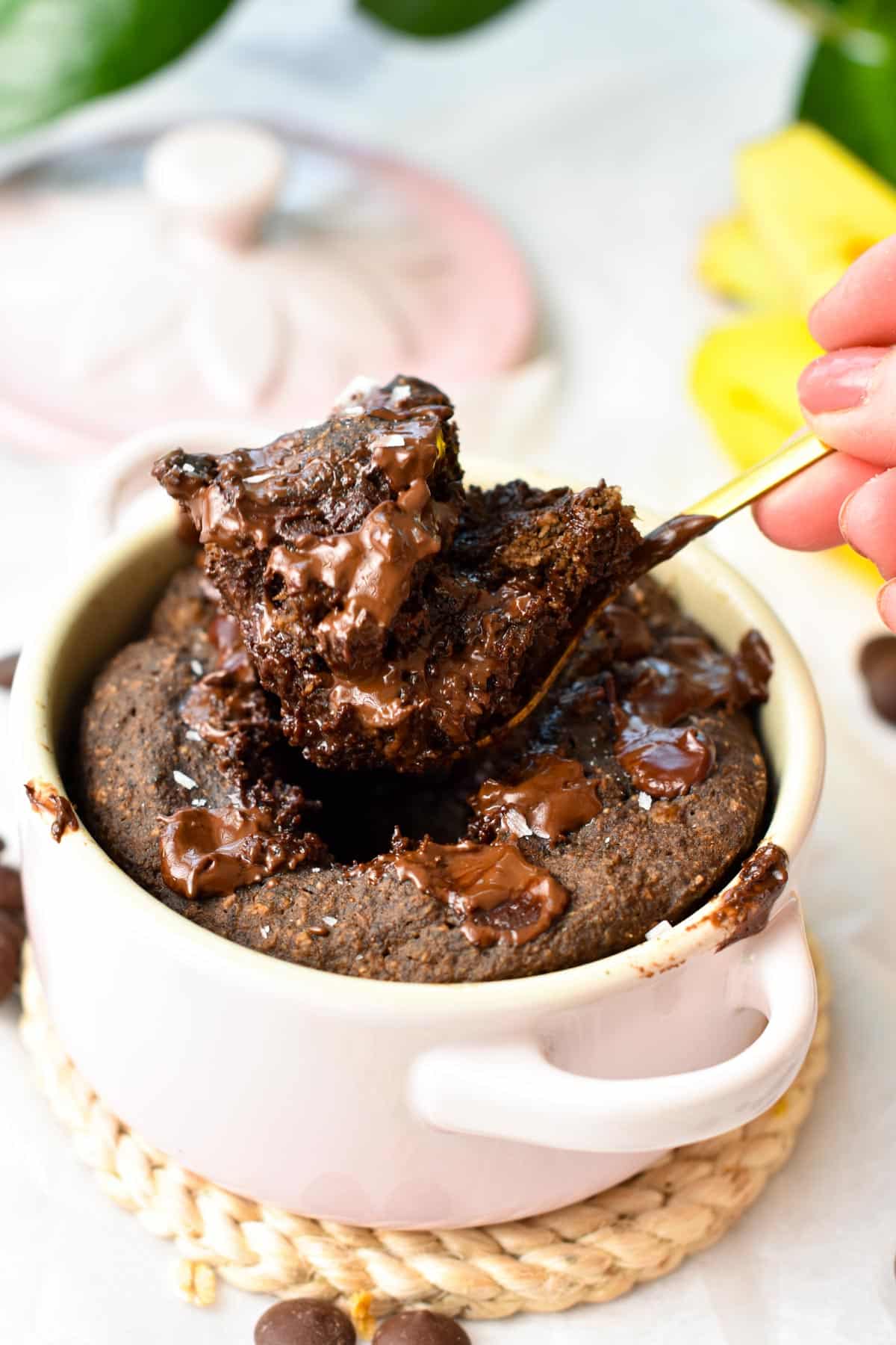 A spoon digging in a protein mug cake and showing the texture of the fudgy chocolate mug cake.