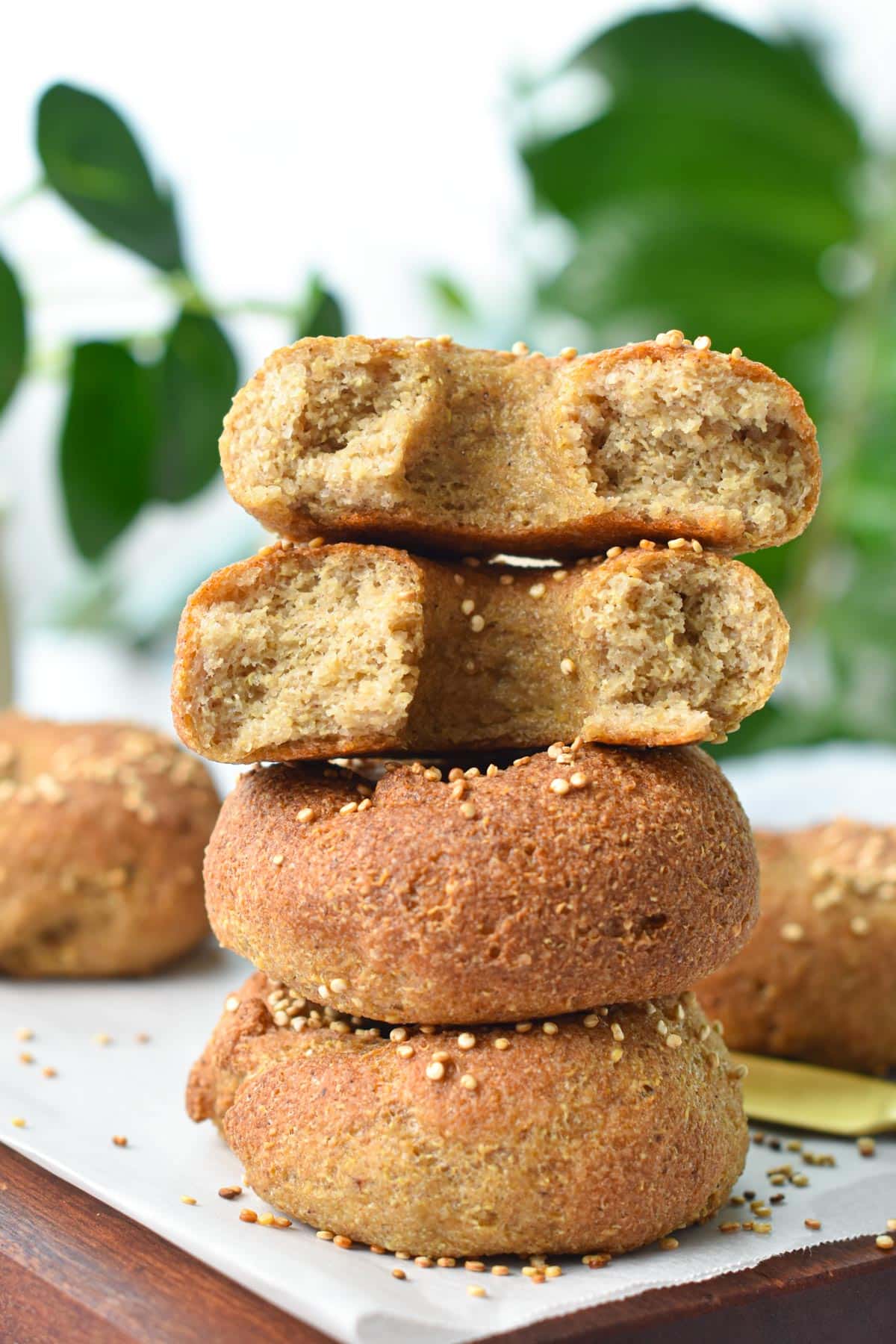 A stack of quinoa bagels with the one one top half open showing the fluffy texture.