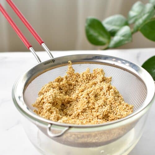 a sieve over a bowl filled with quinoa