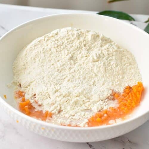 Sweet potato puree in a bowl with self-rising flour.
