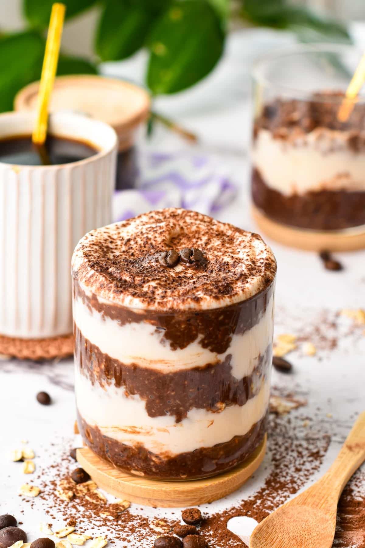 Jar with Tiramisu Overnight Oats next to a coffee mug.