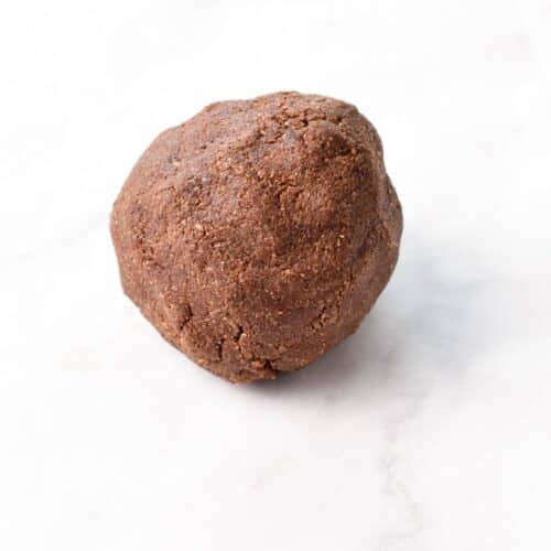 Vegan chocolate shortbread cookie dough rolled into a ball.