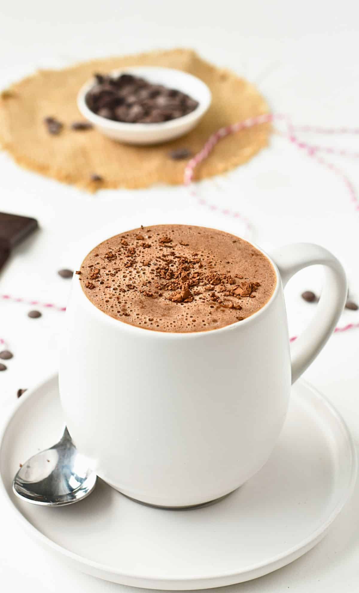 Vegan Hot Cocoa in a cup, decorated with a dust of cocoa.