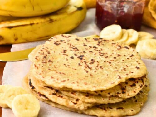 Banana Tortillas stacked on a wooden board.