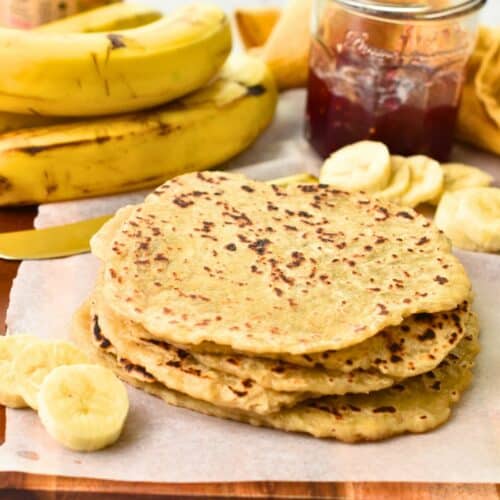 Banana Tortillas stacked on a wooden board.
