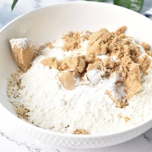 Dry Anzac cookie ingredients in a mixing bowl.