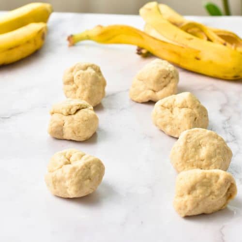 Banana Tortilla dough balls rolled on a table.