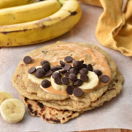 Filling banana tortillas with peanut butter, bananas, and chocolate chips.
