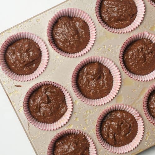Chocolate Protein Muffins in cups on a muffin tin.