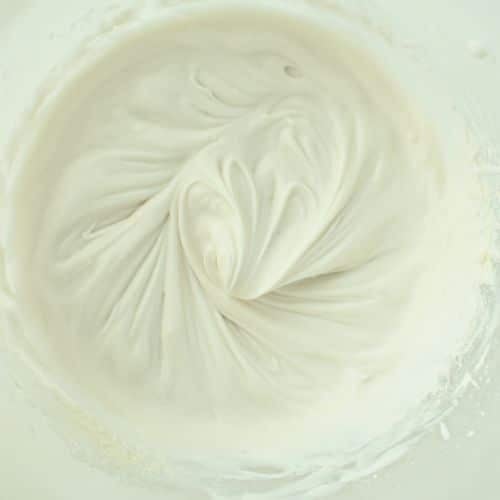 Whipped coconut cream frosting in a mixing bowl.