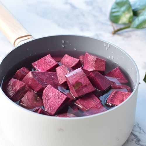 Boiling purple sweet potatoes in a saucepan.