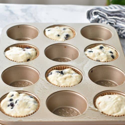 Vegan Blueberry Muffins on a muffin tin ready to bake.